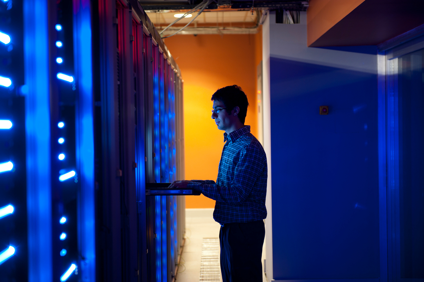 Modern interior of server room in datacenter. IT Engineer in Action Configuring Servers